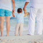 Family on beach with grandchild - Pros And Cons Of Living Near Family small