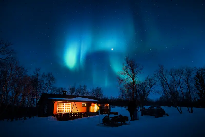 House with snow and northern lights - Pros And Cons Of Living In A Cold Climate With Snow